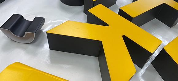 various black and yellow letters arranged on a surface showcasing unique shapes with potential applications in signage and branding related to 6 different concepts