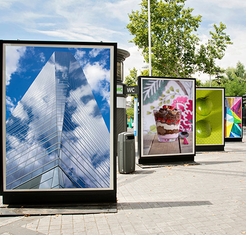 modern skyscraper with clouds and advertising displays featuring dessert and green apple in urban setting