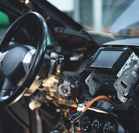 car interior with disassembled dashboard components and steering wheel showcasing electronic wiring and stereo installation 3 systems tools parts